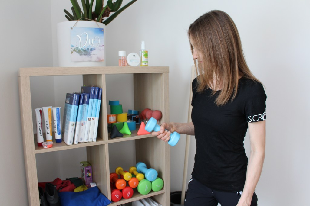 Bild zeigt Physiotherapeutin mit Hanteln